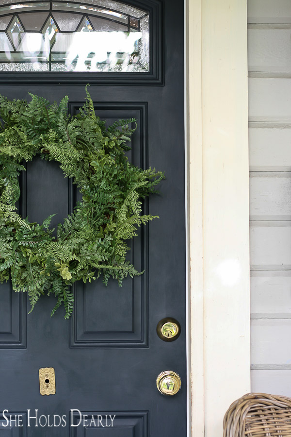 Faux fern wreath on navy blue front door